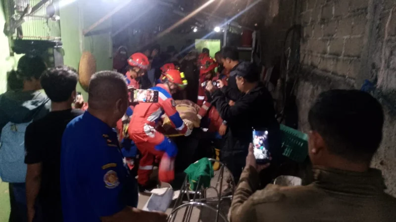 Petugas Damkar mengevakuasi korban dari reruntuhan tembok bangunan yang ambruk di kawasan Koja Jakarta Utara. (Posnews/MR)