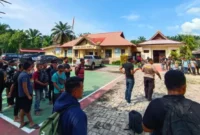 Petugas mengevakuasi puluhan calon pekerja migran Indonesia yang hendak diberangkatkan secara ilegal ke Malaysia dalam pengungkapan kasus TPPO di Dumai, Riau. (Posnews/TVOne)