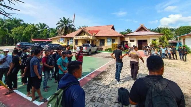 Petugas mengevakuasi puluhan calon pekerja migran Indonesia yang hendak diberangkatkan secara ilegal ke Malaysia dalam pengungkapan kasus TPPO di Dumai, Riau. (Posnews/TVOne)