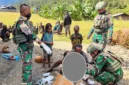 Aparat TNI bersama tenaga kesehatan mengevakuasi warga korban penembakan KKB di Distrik Sinak, Kabupaten Puncak, Papua Tengah, menggunakan ambulans PMI. (Posnews/Ist)