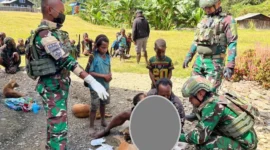Aparat TNI bersama tenaga kesehatan mengevakuasi warga korban penembakan KKB di Distrik Sinak, Kabupaten Puncak, Papua Tengah, menggunakan ambulans PMI. (Posnews/Ist)