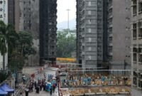 Mencari sisa kenangan. Warga korban kebakaran apartemen paling mematikan di Hong Kong mulai masuk ke reruntuhan rumah mereka guna mencari barang berharga di bawah pengawasan ketat aparat keamanan pada Senin pagi. Dok: REUTERS/Tyrone Siu.