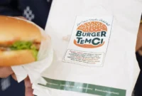 Mahasiswi UNS memamerkan Burger TemCi berbahan tempe dan kentang kleci di ajang Campuspreneur Expo 2026. (Posnews/Ist)