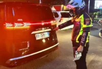 Petugas Satlantas Polresta Tangerang memeriksa mobil listrik BYD Denza dengan pelat nomor menyerupai kode kendaraan pejabat RI di kawasan Cikupa, Tangerang. (Posnews/Ist)