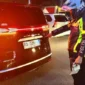 Petugas Satlantas Polresta Tangerang memeriksa mobil listrik BYD Denza dengan pelat nomor menyerupai kode kendaraan pejabat RI di kawasan Cikupa, Tangerang. (Posnews/Ist)
