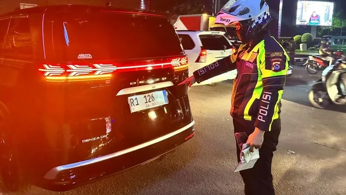 Petugas Satlantas Polresta Tangerang memeriksa mobil listrik BYD Denza dengan pelat nomor menyerupai kode kendaraan pejabat RI di kawasan Cikupa, Tangerang. (Posnews/Ist)