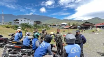 Personel Satgas Ops Damai Cartenz berdialog dengan pedagang dan tukang ojek saat patroli humanis di Pasar Sentral Kota Mulia, Puncak Jaya. (Posnews/Ist0