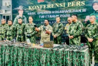 Prajurit TNI menunjukkan senjata api dan amunisi hasil sitaan dari kelompok TPNPB-OPM di Papua. (Posnews/Ist)