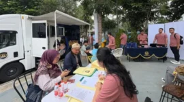 Petugas Kantor Imigrasi Kelas I Non TPI Depok melayani warga yang mengurus paspor dalam kegiatan Car Free Day (CFD) di kawasan Depok Open Space (DOS). (Posnews/Imigrasidepok)