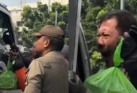 Pengemudi ojek online memohon kepada petugas saat motornya diangkut dalam operasi penertiban parkir liar di Jatinegara Timur, Jakarta Timur. (Posnews/Instagram)
