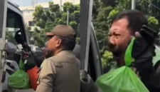 Pengemudi ojek online memohon kepada petugas saat motornya diangkut dalam operasi penertiban parkir liar di Jatinegara Timur, Jakarta Timur. (Posnews/Instagram)