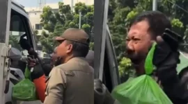 Pengemudi ojek online memohon kepada petugas saat motornya diangkut dalam operasi penertiban parkir liar di Jatinegara Timur, Jakarta Timur. (Posnews/Instagram)