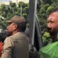 Pengemudi ojek online memohon kepada petugas saat motornya diangkut dalam operasi penertiban parkir liar di Jatinegara Timur, Jakarta Timur. (Posnews/Instagram)