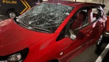 Mobil Honda Brio merah mengalami kerusakan parah setelah diamuk massa di kawasan Grand Galaxy Park, Bekasi Selatan, diduga terkait insiden tabrak lari. (Posnews/Ist)