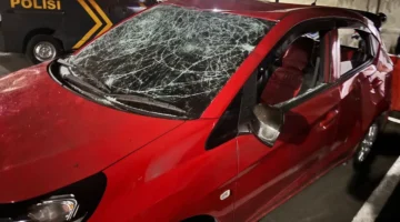 Mobil Honda Brio merah mengalami kerusakan parah setelah diamuk massa di kawasan Grand Galaxy Park, Bekasi Selatan, diduga terkait insiden tabrak lari. (Posnews/Ist)
