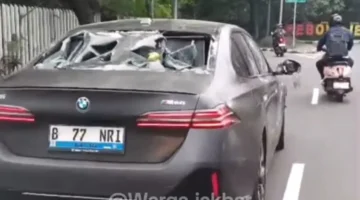 Mobil listrik BMW bernomor polisi B-77-NRI mengalami kerusakan setelah terlibat kecelakaan dengan pengendara motor di Jalan Meruya Selatan, Kebon Jeruk, Jakarta Barat. (Posnews/Instagram)