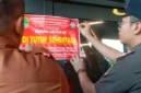 Petugas Satpol PP Kabupaten Karawang memasang segel di Helen's Night Mart setelah menemukan dugaan pesta gay, penjualan minuman beralkohol tanpa izin, dan pelanggaran dokumen bangunan. (Posnews/Ist)