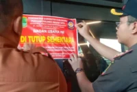 Petugas Satpol PP Kabupaten Karawang memasang segel di Helen's Night Mart setelah menemukan dugaan pesta gay, penjualan minuman beralkohol tanpa izin, dan pelanggaran dokumen bangunan. (Posnews/Ist)