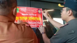 Petugas Satpol PP Kabupaten Karawang memasang segel di Helen's Night Mart setelah menemukan dugaan pesta gay, penjualan minuman beralkohol tanpa izin, dan pelanggaran dokumen bangunan. (Posnews/Ist)