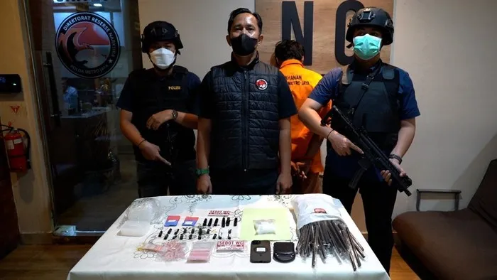 Petugas Ditresnarkoba Polda Metro Jaya menunjukkan barang bukti sabu, tembakau sintetis, dan stiker yang digunakan sebagai kode lokasi tempel narkoba di Cipayung, Jakarta Timur. (Posnews/Ist)