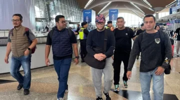 Frans Antony mengenakan topi, pengendali keuangan jaringan narkoba Fredy Pratama, tiba di Jakarta usai ditangkap aparat di Malaysia dan langsung menjalani pemeriksaan di Bareskrim Polri. (Posnews/Ist)
