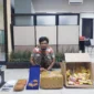 Petugas Dittipidnarkoba Bareskrim Polri menunjukkan tersangka dan barang bukti 5,2 kilogram ganja yang dikirim melalui jasa ekspedisi dan diamankan di Kabupaten Malang, Jawa Timur. (Posnews/ist)

