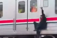 Petugas KAI Commuter mengamankan pria yang bergelantungan di sisi luar rangkaian Commuter Line di Stasiun Ancol. (Posnews/Ist)