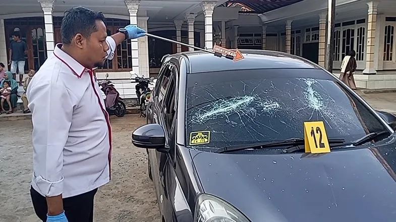 Polisi melakukan olah TKP usai bentrok dua kelompok di Desa Berbeluk, Arosbaya, Bangkalan, yang mengakibatkan seorang warga tertembak dan dua mobil rusak. (Posnews/Polres Bangkalan)
