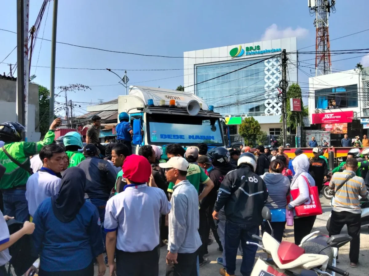  Warga dan petugas mengevakuasi sopir truk kontainer setelah kecelakaan di Jalan Plumpang Raya, Koja, Jakarta Utara. (Posnews/MR)