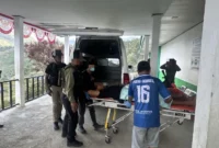 Bripda Jhon Galu Situmorang dievakuasi setelah terluka akibat penembakan di sekitar Jembatan Kuari, Tolikara. (Posnews/Ist)
