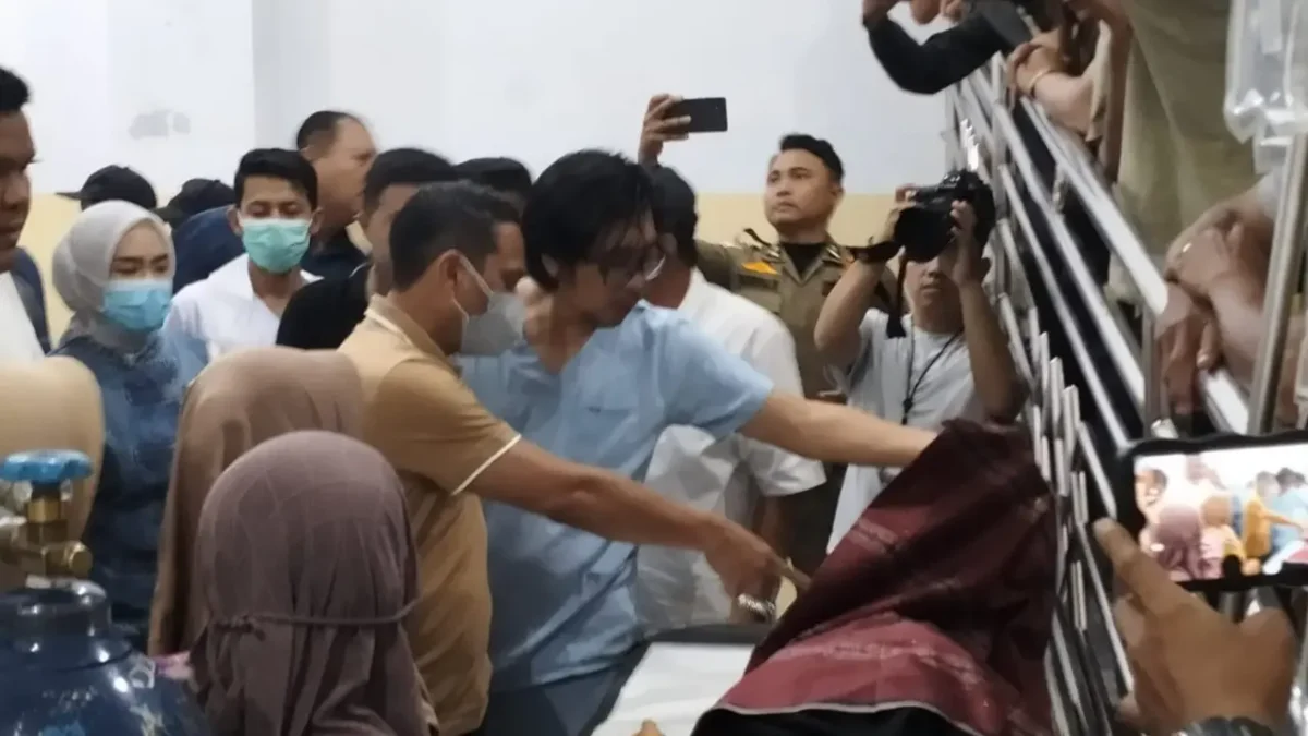 Petugas mengevakuasi korban kecelakaan drag race Kotamobagu setelah Honda Jazz menabrak penonton. (Posnews/Ist)
