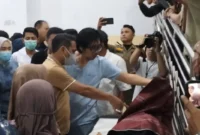Petugas mengevakuasi korban kecelakaan drag race Kotamobagu setelah Honda Jazz menabrak penonton. (Posnews/Ist)
