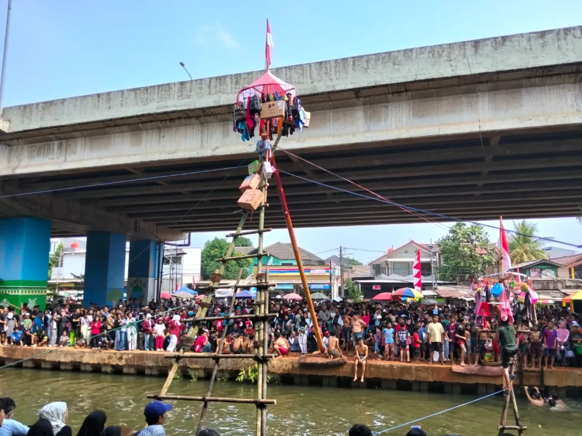 Ribuan warga menyaksikan lomba panjat pinang di atas Sungai Kalimalang, Cipinang Melayu, Jakarta Timur. (Posnews/MR)