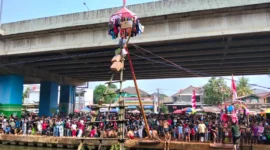 Ribuan warga menyaksikan lomba panjat pinang di atas Sungai Kalimalang, Cipinang Melayu, Jakarta Timur. (Posnews/MR)