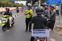 Petugas Ditlantas Polda Metro Jaya mengawasi pengendara di titik rawan pelanggaran lalu lintas. (Posnews/Humas PMJ)
