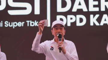Joko Widodo menunjukkan KTA PSI saat menghadiri Rakorda PSI Kabupaten Bekasi
