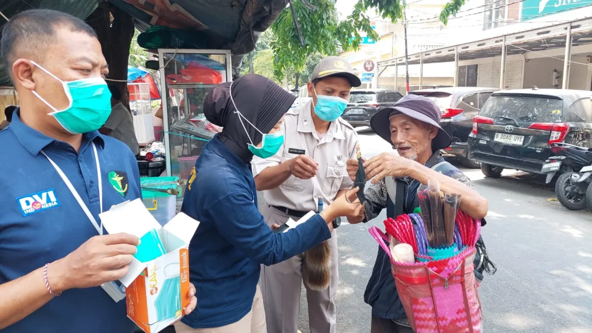 Personel Si Dokkes Polres Metro Jakarta Utara membagikan masker kepada warga untuk mengantisipasi abu vulkanik Anak Krakatau. (Posnews/Polres Metro Jakut)
