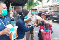 Personel Si Dokkes Polres Metro Jakarta Utara membagikan masker kepada warga untuk mengantisipasi abu vulkanik Anak Krakatau. (Posnews/Polres Metro Jakut)