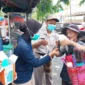 Personel Si Dokkes Polres Metro Jakarta Utara membagikan masker kepada warga untuk mengantisipasi abu vulkanik Anak Krakatau. (Posnews/Polres Metro Jakut)
