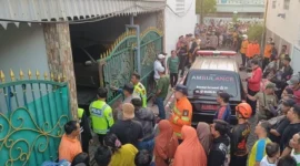 Petugas mengevakuasi dua bocah korban kebakaran rumah di Simorejo Surabaya. (Posnews/Ist)
