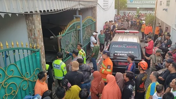 Petugas mengevakuasi dua bocah korban kebakaran rumah di Simorejo Surabaya. (Posnews/Ist)

