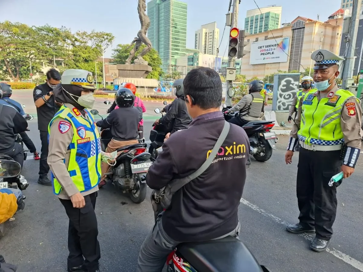 Polisi membagikan masker kepada pengemudi ojol untuk mengantisipasi paparan abu vulkanik Anak Krakatau di Jakarta. (Posnews/Ist)
