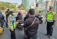 Polisi membagikan masker kepada pengemudi ojol untuk mengantisipasi paparan abu vulkanik Anak Krakatau di Jakarta. (Posnews/Ist)