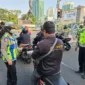 Polisi membagikan masker kepada pengemudi ojol untuk mengantisipasi paparan abu vulkanik Anak Krakatau di Jakarta. (Posnews/Ist)
