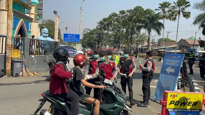 Polisi membagikan masker kepada pengendara di Bogor untuk mengantisipasi paparan abu vulkanik Gunung Anak Krakatau. (Posnews/Ist)
