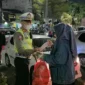 Polisi membagikan masker kepada warga Bekasi untuk mengantisipasi paparan abu vulkanik Gunung Anak Krakatau. (Posnews/Ist)
