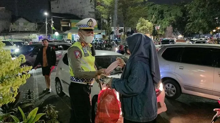 Polisi membagikan masker kepada warga Bekasi untuk mengantisipasi paparan abu vulkanik Gunung Anak Krakatau. (Posnews/Ist)
