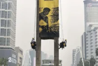 Enam aktivis Greenpeace Indonesia dievakuasi setelah membentangkan spanduk di Monumen Selamat Datang, Bundaran HI, Jakarta Pusat. (Posnews/Greenpeace Indonesia)

