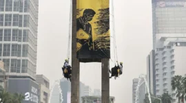 Enam aktivis Greenpeace Indonesia dievakuasi setelah membentangkan spanduk di Monumen Selamat Datang, Bundaran HI, Jakarta Pusat. (Posnews/Greenpeace Indonesia)

