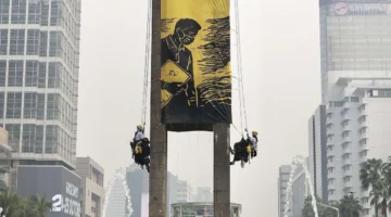 Enam aktivis Greenpeace Indonesia dievakuasi setelah membentangkan spanduk di Monumen Selamat Datang, Bundaran HI, Jakarta Pusat. (Posnews/Greenpeace Indonesia)

